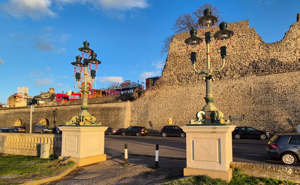The ornate lights at the northern entrance to Esplanade Gardens, with the castle wall in the background