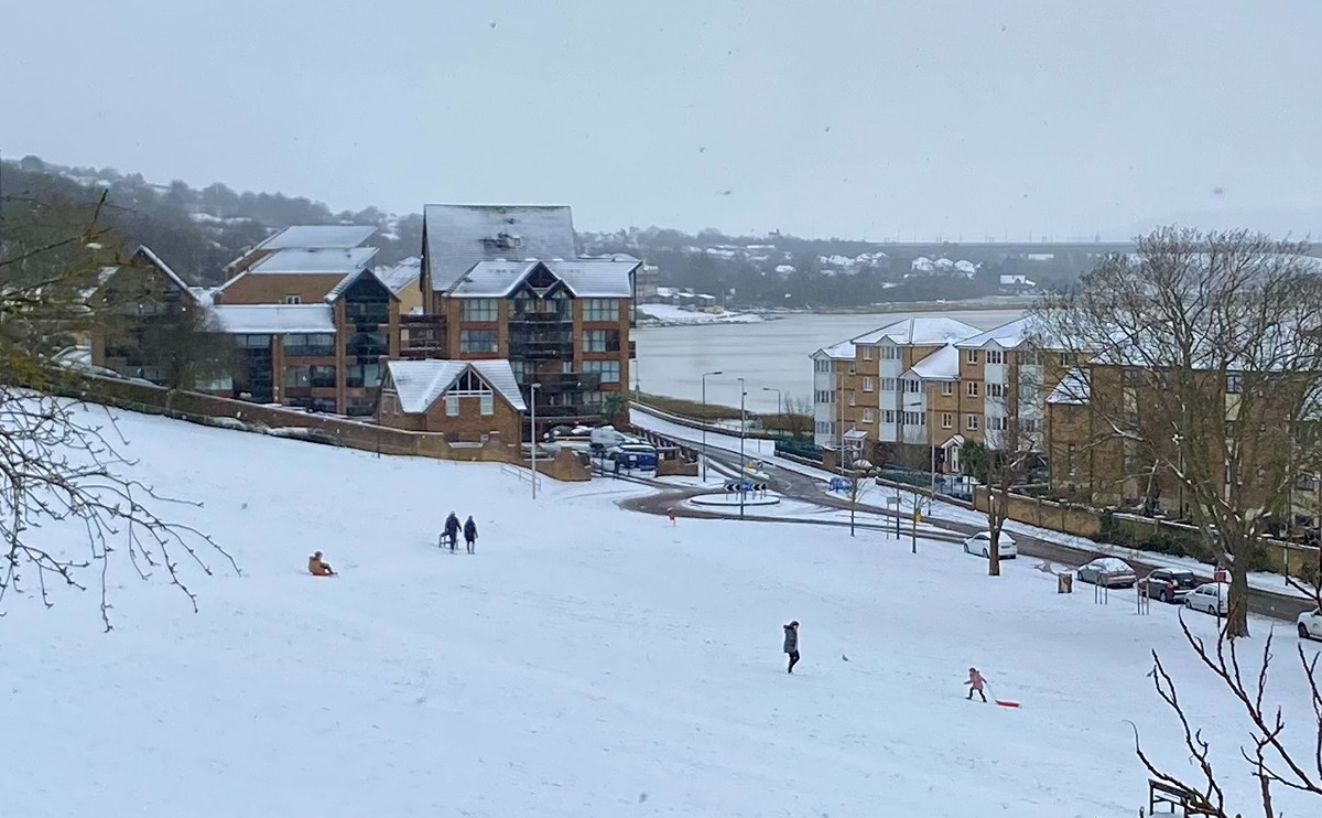 People sledging on a snow-covered slope